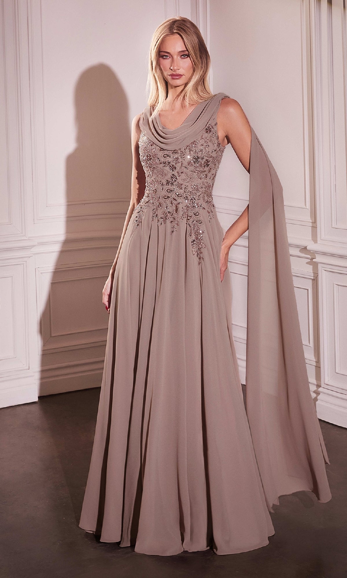 A woman stands in a formal room wearing the Ladivine CDS509 Shoulder Sash Long Formal Dress, featuring floral embroidery on the bodice and a draped sash over one shoulder.